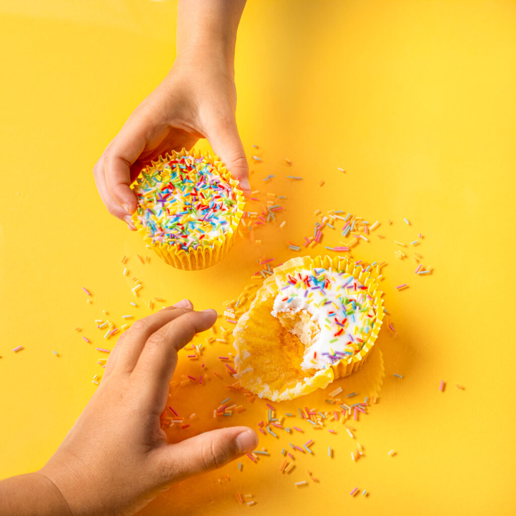 Children about to eat cupcake with sprinkles