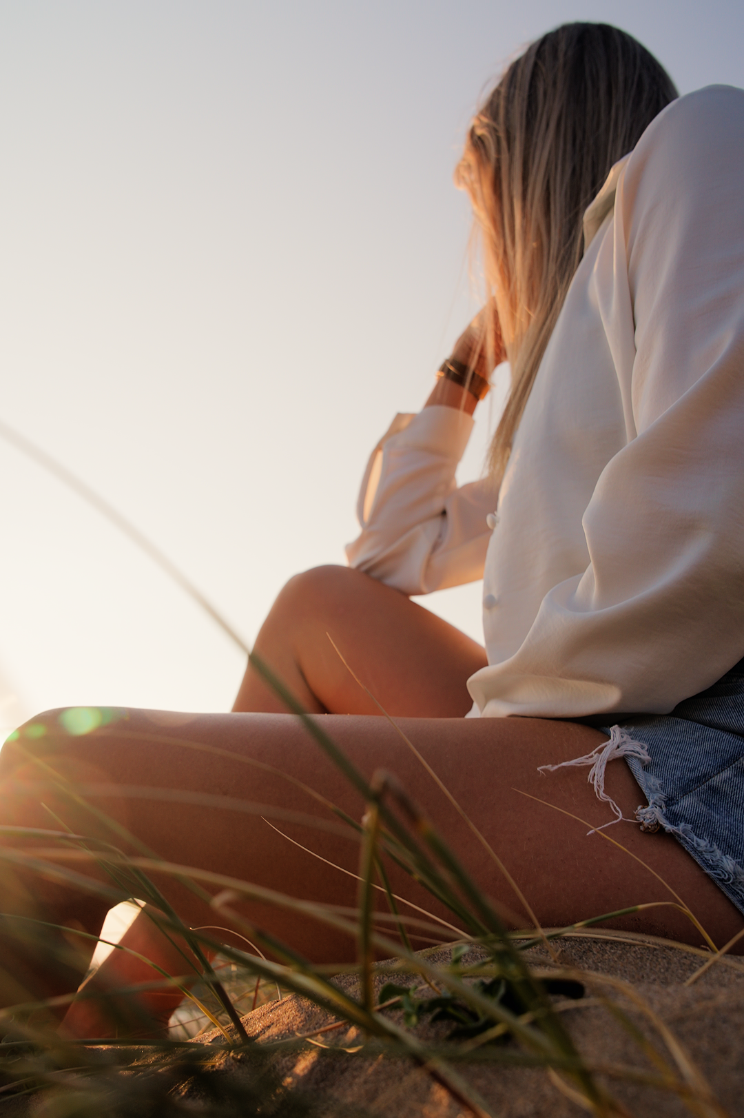 Woman seated in beach grass during a lifestyle branding video shoot